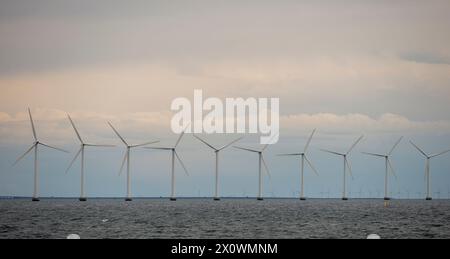 Dieses Stockbild zeigt den beeindruckenden Offshore-Windpark Middelgrunden, der sich in der Nähe der Küste von Kopenhagen, Dänemark, befindet. Die Windräder stehen hoch Stockfoto