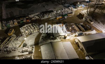 Drohnenfotografie von Metall-Recycling-Anlagen in der Nacht und Metallhaufen in der winterlichen bewölkten Nacht Stockfoto