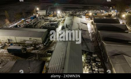 Drohnenfotografie von Metall-Recycling-Anlagen in der Nacht und Metallhaufen in der winterlichen bewölkten Nacht Stockfoto