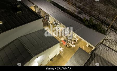 Drohnenfotografie von Metall-Recycling-Anlagen in der Nacht und Metallhaufen in der winterlichen bewölkten Nacht Stockfoto