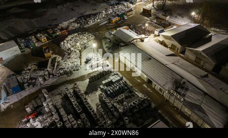 Drohnenfotografie von Metall-Recycling-Anlagen in der Nacht und Metallhaufen in der winterlichen bewölkten Nacht Stockfoto