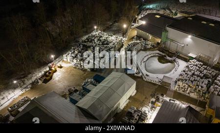 Drohnenfotografie von Metall-Recycling-Anlagen in der Nacht und Metallhaufen in der winterlichen bewölkten Nacht Stockfoto