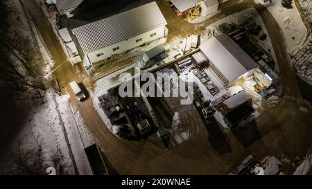 Drohnenfotografie von Metall-Recycling-Anlagen in der Nacht und Metallhaufen in der winterlichen bewölkten Nacht Stockfoto