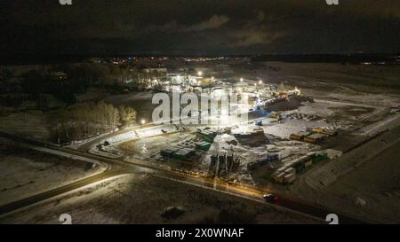 Drohnenfotografie von Metall-Recycling-Anlagen in der Nacht und Metallhaufen in der winterlichen bewölkten Nacht Stockfoto