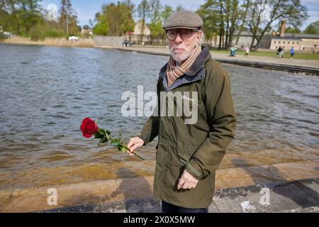 14. April 2024, Brandenburg, Fürstenberg/Havel: Holocaust-Überlebende Ib Katznelson steht mit einer Rose am Schwedtsee während der zentralen Gedenkveranstaltung zum 79. Jahrestag der Befreiung des Frauenlager Ravensbrück. Foto: Jörg Carstensen/dpa Stockfoto