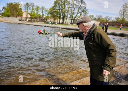 14. April 2024, Brandenburg, Fürstenberg/Havel: Holocaust-Überlebender Ib Katznelson wirft im Rahmen der zentralen Gedenkfeier anlässlich des 79. Jahrestages der Befreiung des Frauenlager Ravensbrück eine Rose in den Schwedtsee. Foto: Jörg Carstensen/dpa Stockfoto