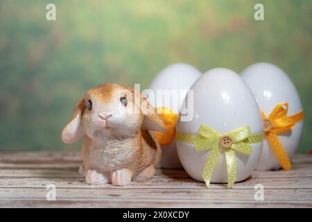 Eier in eine bunte Geschenkkrawatte mit einem Kaninchen gewickelt. Oster-, Pascha- oder Auferstehungssonntag-Konzept Stockfoto