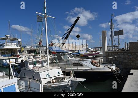 Yachten, Segelboote und alte Holzboote mit weißen Rümpfen im griechischen Hafen von Heraklion in der Nähe des Stadtzentrums im Sommer. Stockfoto