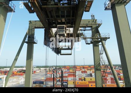 Grüner Portalkran mit weißer Kabine, betrieben von Stauhallen im Containerterminal Houston. Stockfoto