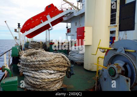 Orange Freifall Rettungsboot gesichert auf weißer Startrampe und bereit, Schiff mit Besatzung in Notsituationen zu starten und zu verlassen. Stockfoto