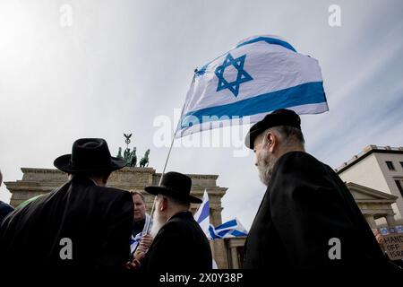 Hunderte Demonstranten versammelten sich am Sonntag, den 14. April 2024, am Brandenburger Tor in Berlin, um unter dem Banner "Hände weg von Israel! Wir stehen gemeinsam gegen den Terror des iranischen Regimes." Die Veranstaltung am Pariser Platz war geprägt von Aufrufen zur Solidarität mit Israel nach den beispiellosen direkten Angriffen aus iranischem Boden. Die Redner der Veranstaltung hoben den Start von Hunderten von Drohnen und Kreuzfahrtraketen durch den Iran als eine erhebliche Eskalation hervor. Die Versammlung betonte, dass der Iran nicht nur eine regionale, sondern auch eine internationale Bedrohung sei. Der Aufruhr beim Berliner Demonstrat Stockfoto