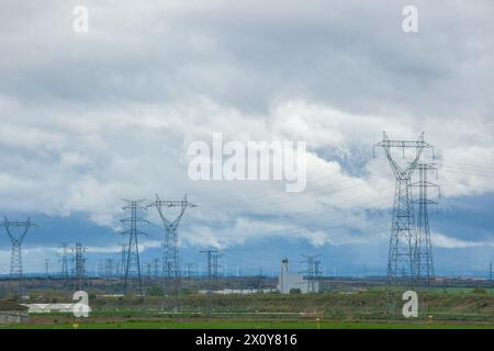 Ländliche Landschaft, versteckt von elektrischen Türmen, Hochspannungskabeln und Windturbinen. Umweltverträglichkeitskonzept für Windturbinen Stockfoto