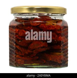 Glas mit eingelegten getrockneten Tomaten auf weißem Hintergrund. Getrocknete Tomaten mit Gewürzen in einem Glas Isolat Stockfoto