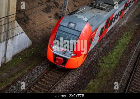 Moskau, Russland. April 2024. Blick von oben auf einen elektrischen Lastochka-Zug, der entlang der Strecke in Moskau, Russland, fährt Stockfoto
