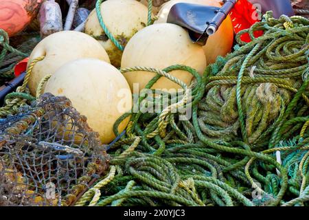 Nahaufnahme eines Gemischs von Küstenfischerei, die sich am Ufer des Hafens von Arbroath stapelt, Kreelen, Krabben- oder Hummertöpfe, Seile, Schwimmer und Markierungsflaggen. Stockfoto