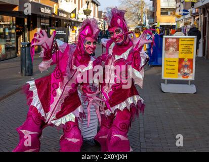 Noordwijkerhout, Niederlande - 21. April 2023: Frauen in rosa Märchenkostümen auf der Straße in Noordwijkerhout vor dem Abend erleuchtete Flowe Stockfoto