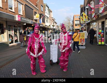 Noordwijkerhout, Niederlande - 21. April 2023: Frauen in rosa Märchenkostümen auf der Straße in Noordwijkerhout vor dem Abend erleuchtete Flowe Stockfoto