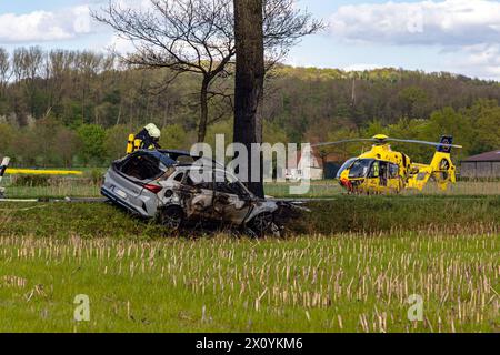 Bissendorf LK Osnabrück, Deutschland 14. April 2024: Tödlicher Verkehrsunfall - LK - Osnabrück - 2 Personen sterben - 14.04.2024 im Bild: PM: 14.04.24, 17:05: VU tödlich - 49143 Bissendorf - Mindener Straße - ein PKW kommt aus bislang ungeklärter Ursache alleinbeteiligt von der Fahrbahn ab, kollidiert mit einem Baum und gerät in Vollbrand. Die Fahrzeugführerin und ein weiterer Fahrzeuginsasse werden dabei tödlich verletzt. Polizei, Feuerwehr und Rettungsdienst sind vor Ort. Ein Rettungshubschrauber ist im Einsatz. Die Verkehrsunfallaufnahme dauert an. Die Mindener Straße ist aktuell für BE Stockfoto