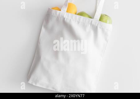 Weißer Beutel mit Obst auf einem weißen Tisch. Stockfoto