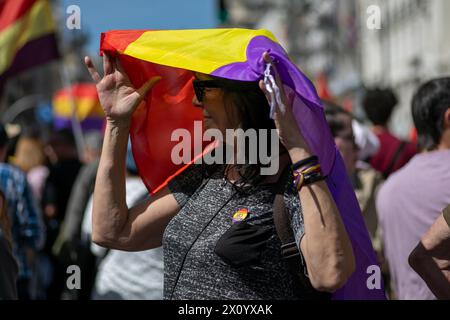 Madrid, Spanien. April 2024. Eine Frau beschützt während einer Demonstration ihren Kopf mit einer spanischen republikanischen Flagge. Hunderte von Menschen haben im Zentrum von Madrid demonstriert, um dem 93. Jahrestag der Zweiten Spanischen Republik zu gedenken. Die zweite spanische Republik wurde am 14. April 1931 ausgerufen und 1936 durch einen Staatsstreich unterbrochen, der zu einem Bürgerkrieg führte. (Foto: David Canales/SOPA Images/SIPA USA) Credit: SIPA USA/Alamy Live News Stockfoto