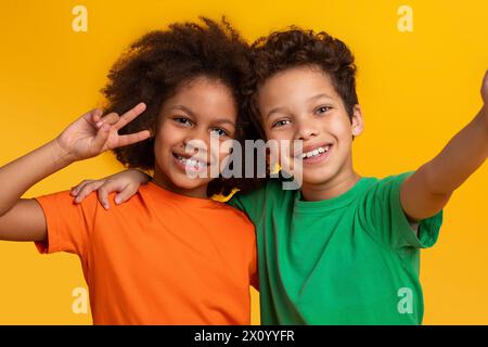 Fröhliche Kinder posieren mit Friedenszeichen, machen Selfie Stockfoto