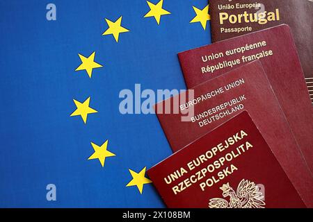 eu-Länder Pässe auf blauer EU-Flagge aus nächster Nähe. Portugiesische, deutsche, französische und polnische Reisepässe Stockfoto