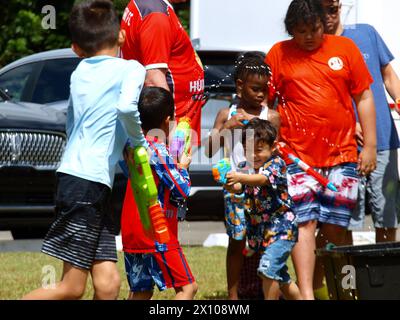 Miami, Florida, USA - 14. April 2024: Kinder spielen mit Wasserpistolen bei der Songkran-Feier im Wat Buddharangsi Buddhist Temple. Stockfoto