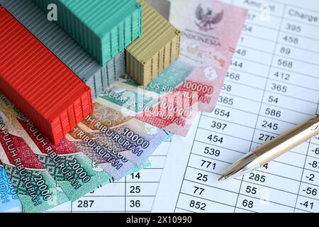 Globale Business Container Frachtschiff in Import Export Business Logistik. Firmenversand und Logistik in Indonesien mit Rupiah-Geldrechnungen und Pen-Nahaufnahme Stockfoto