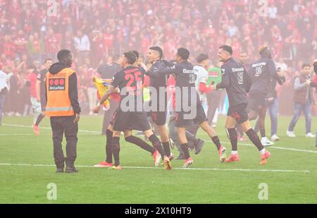 Leverkusen, Deutschland. April 2024. Granit Xhaka, Lev 34 Exequiel PALACIOS, Lev 25 Edmond TAPSOBA, Lev 12 umgeben von feierlichen Fans auf dem Platz nach dem Spiel BAYER 04 LEVERKUSEN - SV WERDER BREMEN 5-0 am 14. April 2024 in Leverkusen. Saison 2023/2024, 1.Bundesliga, Spieltag 29, 29.Spieltag Fotograf: ddp Images/Star-Images - DFL-VORSCHRIFTEN VERBIETEN JEDE VERWENDUNG VON FOTOS als BILDSEQUENZEN und/oder QUASI-VIDEO - Credit: ddp Media GmbH/Alamy Live News Stockfoto