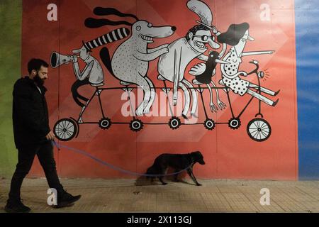 Santiago, Metropolitana, Chile. April 2024. Ein Mann und sein Hund spazieren vor einem Wandgemälde des Künstlers Alberto Montt in Santiago, Chile. (Kreditbild: © Matias Basualdo/ZUMA Press Wire) NUR REDAKTIONELLE VERWENDUNG! Nicht für kommerzielle ZWECKE! Stockfoto