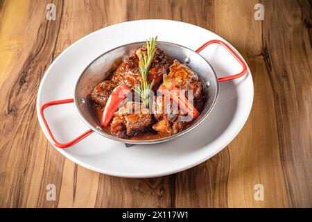 Ochsenschwanzschale mit Rosmarin-Garnitur-Metallplatte Stockfoto