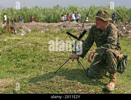 Sgt Joshua T. Bavender, das Bataillon Landing Team, 3. Bataillon, 2. Marine Regiment, 22. Marine Expeditionary Unit, Kommandant des Funkdienstes des Offiziers, und gebürtig aus Idaho Springs, Co., hält eine Funkantenne fest, während ein UH-1N Hubschrauber der Marine Heavy Helicopter Squadron 461 (verstärkt), 22. MEU, sich auf den Start von einer Landezone in Leogane, Haiti, vorbereitet, 20. Januar 2010. Stockfoto