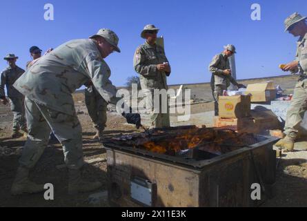 Soldaten der C-Kompanie, 2. Bataillon, 124. Infanterieregiment, mit dem 53. Infanterie-Brigade-Kampfteam, die nach ihrer Ankunft in Südwestasien ein Kochen in ihrem Wohnbereich genossen, bevor sie 2003 in den Irak zogen. Stockfoto