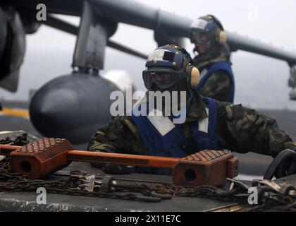 Der Flieger Michael Aranas, der Kamerad des Flugbootes, unterstützt einen Flugzeugtraktor auf dem Flugdeck des vorgelagerten amphibischen Angriffsschiffs USS Essex. Essex ist auf dem Weg zu ihrer jährlichen Frühjahrspatrouille im westlichen Pazifik, CA. Januar 2004 (Datum pro Metadaten ist 2010) Stockfoto