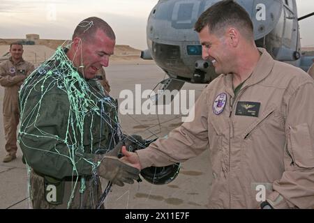 Lieutenant Col. Robert Boucher (rechts), Befehlshaber der Marine Medium Helicopter Squadron 364, präsentiert Stabsregent James McGuinness, einen Crewchef mit HMM-364, mit einem Patch zur Erinnerung an McGuinness' 5.000ste Flugstunde mit dem CH-46 Sea Knight an Bord der Al Asad Air Base, Irak, am 12. Januar 2010. Stockfoto