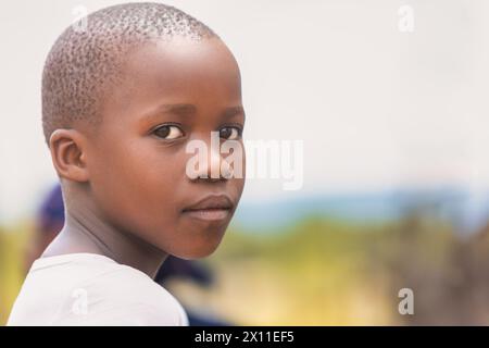 Porträt eines glücklichen afrikanischen Kindes mit einem Lächeln, draußen im Dorf Stockfoto