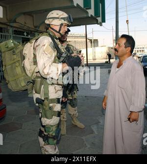 Lt. John Robinson spricht mit einem Iraker während einer Patrouille in Mossul. Als Ärzteassistent des 1. Bataillons, 23. Infanterieregiment, begleitet Robinson die Infanterie bei Kampfeinsätzen. Während dieser Missionen besucht Robinson oft Iraker und erkundigt sich nach ihrer Gesundheit. Juni 2004 Stockfoto
