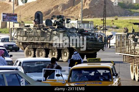 Originalunterschrift: Soldaten des 2. Bataillons, 3. Infanterieregiments, fahren in einem Stryker-Konvoi durch einen Verkehrsstau in Mossul, Irak. Als Teil der 3. Brigade, 2. Infanteriedivision (Stryker Brigade Combat Team), sind die Soldaten unter den Ersten, die das Fahrzeug je in einer Kampfzone ca. April 2004 Stockfoto