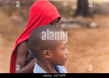 Porträt afrikanischer Kinder, die draußen im Dorf spielen Stockfoto