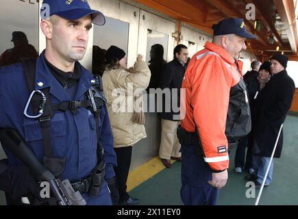 NEW YORK, New York (8. Januar 2004)--Petty Officer 3rd Class Chad Walder von Franklin Lakes, N.J., patrouilliert am 8. Januar 2004 im Hafen von New York auf einer Staten Island Ferry mit Mitgliedern eines kommerziellen Schiffsboardteams. Stockfoto