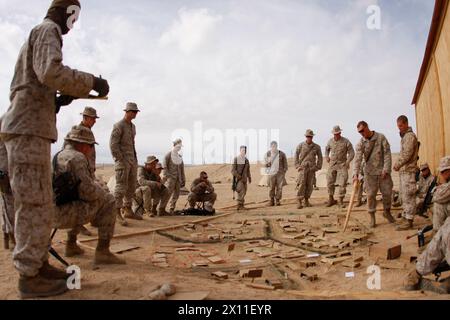 Marines und Matrosen mit 1. Zug, Kompanie K, 3. Bataillon, 1. Marine-Regiment, vom Marine Corps Base Camp Pendleton, Kalifornien, hören einem ihrer Feuerwehrtruppenführer während einer Nachbesprechung nach einer Patrouille am 31. Januar 2010 zu. Das Bataillon arbeitete in Räumungshäusern, sowie mit Zivilisten in ihren Patrouillen, hier im Combat Center Range 220. Stockfoto