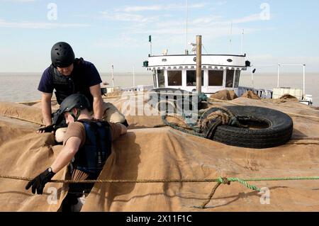 ARABISCHER GOLF (5. Januar 2004)-- Mitglieder eines Boarding-Teams der US-Küstenwache Cutter Adak durchsuchen eine Fracht-Dhow nach illegalen Gütern. die Küstenwache hat vier 110-Fuß-Patrouillenboote in die Region geschickt, um die 5. Flotte der US Navy und Koalitionstruppen während der Operation Iraqi Freedom und maritime Abhöroperationen zu unterstützen, um illegale Einsätze zu stoppen Ölschmuggel und die Suche nach Terroristen. Stockfoto