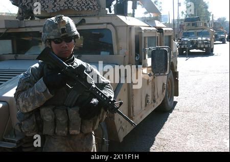 Ein Armeespezialist mit Kompanie A, 1. Bataillon, 64. Panzerregiment, dem 2. Brigade-Kampfteam, 101. Luftlandedivision (Air Assault), angehört, zieht die Sicherheit in Adil, dem Mansour-Distrikt von Bagdad, CA. 2004 Stockfoto