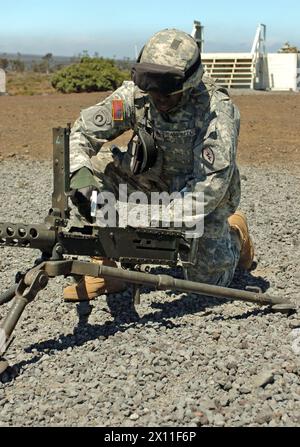 Originalunterschrift: Stabsleiter Eric Campbell mit dem 209. Aviation Support Battalion, 25. Combat Aviation Brigade, inspiziert eine Waffe während einer Übung im Pohakuloa Training Area ca. 2004 Stockfoto