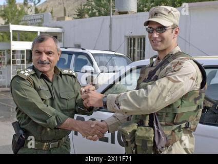 Sgt. Jeffrey Gliem, der Leiter des Sicherheitsteams des 416. Bataillons für Zivilsachen Dahuk, übergibt Brig die Schlüssel für eines von zwei neuen Polizeipatrouillenfahrzeugen. General Nazar Aziz, Polizeichef des Gouvernements Dahuk CA. April 2004 Stockfoto