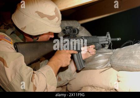 Als Soldat bei Kompanie C, 276. Maschinenbataillon, überwacht Elliott Woods seine Verteidigungsstellung während einer Übung, die Soldaten auf der Forward Operating Base vorbereitet, die regelmäßig auf Feinde in das Gelände eindringen. Mai 2004 Stockfoto