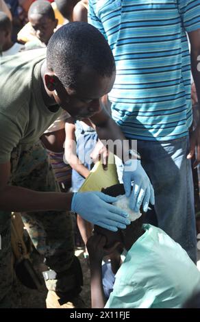 Kalyl Traore, ein Hospitalmann und ein Korpsant mit dem Führungsteam des Bataillons, 3. Bataillon, 2. Marine-Regiment, 22. Marine-Expeditionseinheit, behandelt eine Kopfwunde an einem haitianischen Jungen während einer medizinischen Mission in Dano, Haiti, 28. Januar. Stockfoto