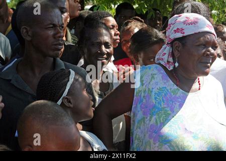 Eine Gruppe Haitianer aus Cotes de Fer empfängt Marines von der 22. Marine Expeditionary Unit am 21. Januar 2010. Marines und Seeleute aus der 22. MEU errichteten in der Nähe von Cotes de Fer (Haiti) eine vorübergehende Verteilung von Hilfsgütern, die Wasser und Nahrungsmittel in Flaschen für die Verteilung an die Binnenvertriebenen Haitianer brachten. Stockfoto