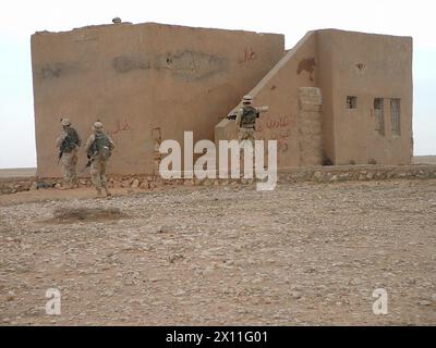 Soldaten der C-Kompanie, 2. Bataillon, 124. Infanterieregiment, mit dem 53. Infanterie-Brigade-Kampfteam durchsuchen ein Gebäude im Irak, während sie am 16. April 2003 patrouillieren. Stockfoto