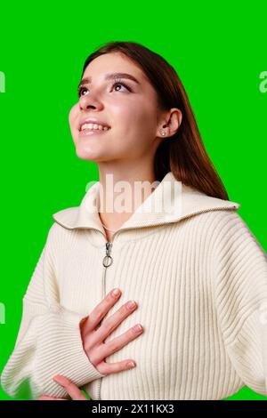 Eine Frau mit weißem Pullover und grauem Rock steht in lässiger Pose und zeigt ihr stylisches Outfit. Stockfoto